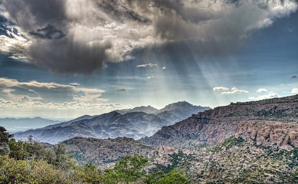Rays of light during monsoon rains over the Catalina Mountains outside Tucson, Arizona.