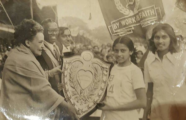 The author’s sister, Karen Mayer, receiving the best all-round athlete award with their father (in glasses) looking on. Circa 1980. 