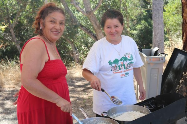 Navigators Maria and Guadalupe cooking outdoors.