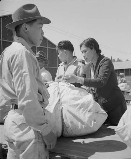 Baggage is inspected as Japanese American families arrive in Turlock, California, en route to War Relocation Authority centers. Photo by Dorothea Lange, courtesy of the National Archives and Records Administration/Densho Digital Reposity.