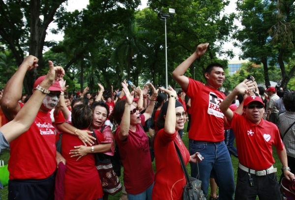 Members of the United Front for Democracy against Dictatorship (UDD) or Red Shirt cheer for news report of the by-election at Lumpini park in Bangkok, Thailand, July 2010. About 200 UDD members took part in the gathering to show their unity and to defy the country's security act. Photo by Apichart Weerawong/Associated Press.