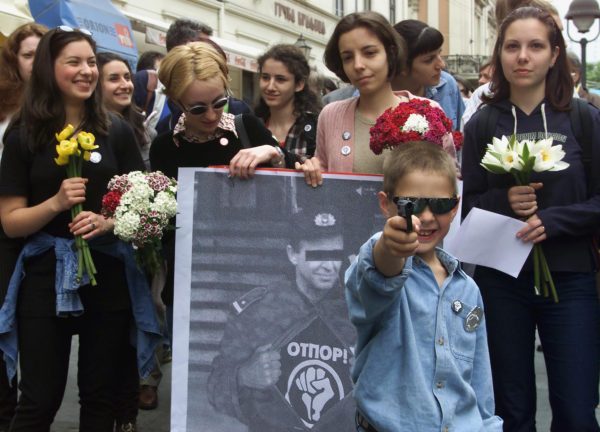 An unidentified Belgrade boy holds a plastic toy gun mocking police officers in Belgrade, Serbia, May 2000. Members of the pro-opposition student group Otpor, or Resistance, gave out flowers to policemen and appealed for their restraint in the worsening government crackdown on political opponents. Photo by Darko Vojinovic/Associated Press.