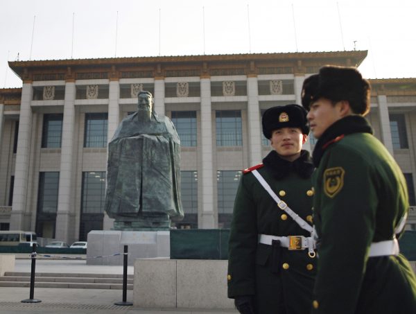 Chinese paramilitary policemen stand guard in front of a sculpture of the ancient philosopher Confucius on display near Tiananmen Square in Beijing, Jan. 2011. Photo by Andy Wong/Associated Press.