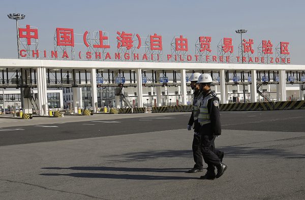 Security guards patrol the main gate of the China (Shanghai) Pilot Free Trade Zone at the Pudong International Airport in Shanghai, China, Nov. 29, 2013. The free trade zone was launched to free up cross-border commodity and capital flows in the world's second largest economy. Photo by Eugene Hoshiko/Associated Press. 