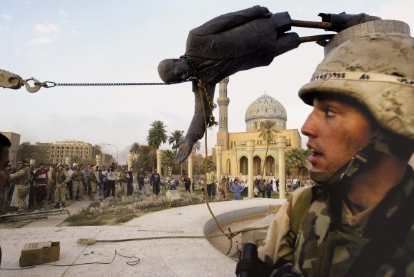 Iraqi civilians and U.S. soldiers pull down a statute of Saddam Hussein in Baghdad, April 9, 2003. Photo by Jerome Delay/Associated Press. 