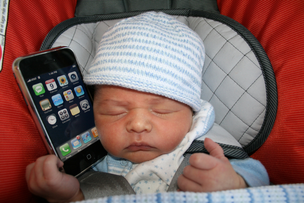Можно ли ребенку айфон. Ребенок с айфоном. Малыш с айфоном. Маленький айфон для детей. Ребенок с айфоном фото.