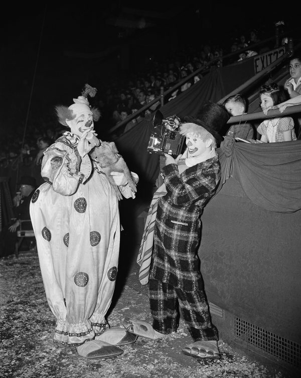 Kenneth Lucas, clown photographer, takes a picture of Felix Adler, "The King of Clowns," at the Ringling Bros. and Barnum & Bailey Circus in New York, May 2, 1944. Adler feeds a piglet with a bottle to the delight of the children in the audience. Photo by Charles Kenneth Lucas/Associatrd Press.