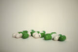 Pills, colored half green and white, against a dimming white background. On the white part of the pill, there is a drawn smiling face, with the eyes in the shape of a heart.